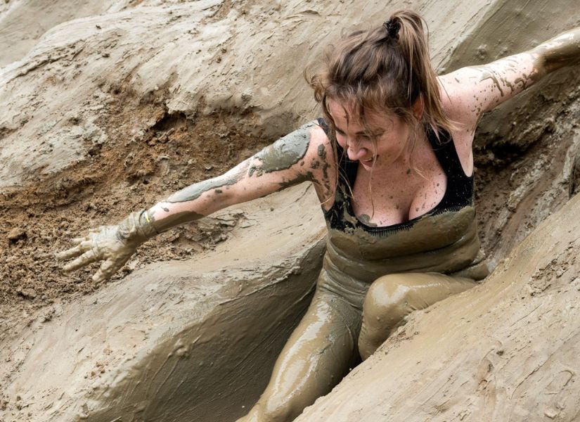 vrouw die door de modder glijdt tijdens de 4 km run van strong viking
