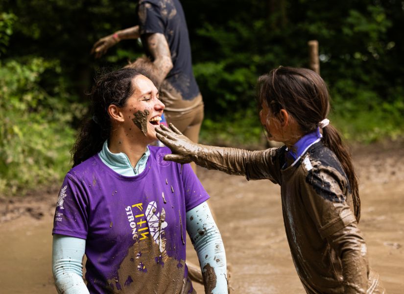 een meisje dat modder in het gezicht smeert tijdens de family run van strong viking