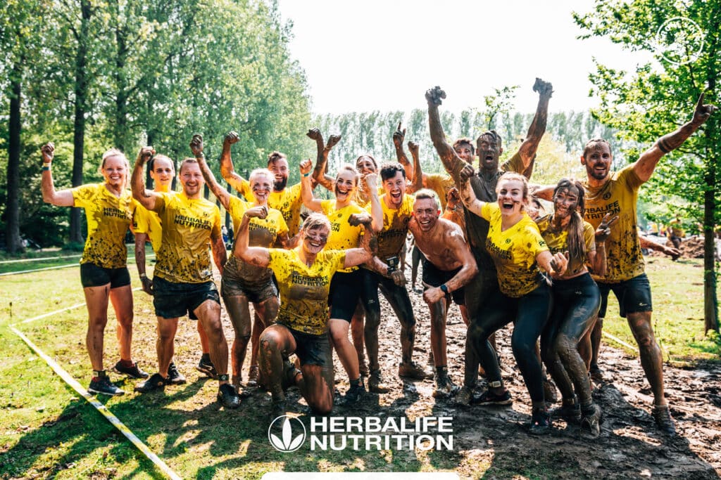 Herbalife Nutrition team group photo after Strong Viking, covered in mud.