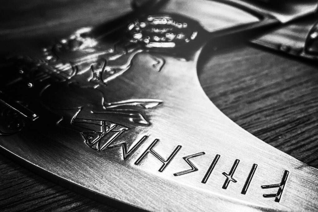 Close-up of the Sleipnir Axe medal in grayscale.