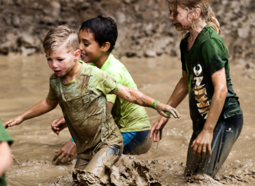 Children running through the mud during an active obstacle run birthday party. Fun idea for a kids' party in Nijmegen, Wijchen, Amsterdam, Arnhem, Ghent.