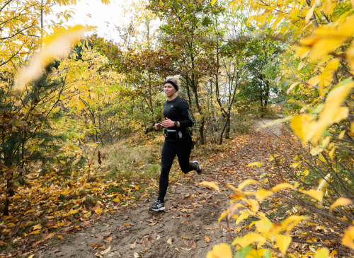 A woman running through the sand during the Strong Viking Trail Run in Wijchen. Running for beginners. Building up running.