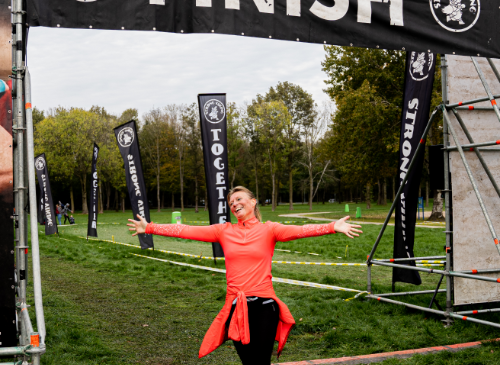 A woman arriving at the finish of the Strong Viking trail run. Running for beginners. Building up running.