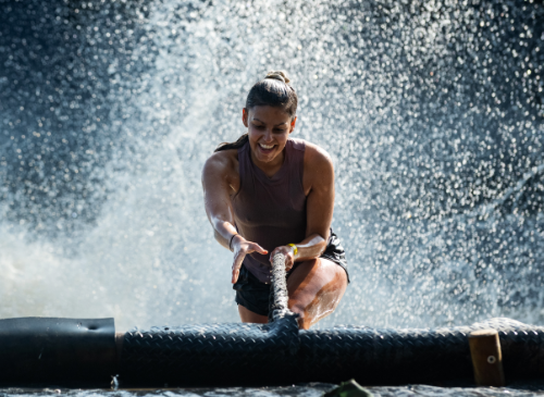 een vrouw die uit het water klimt met een touw na de fjord drop - een echte adrenaline rush