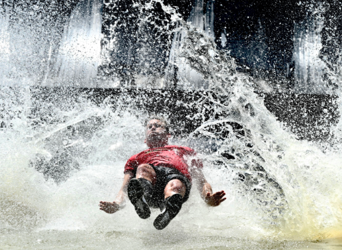 een man die van de fjord drop glijdt het water in